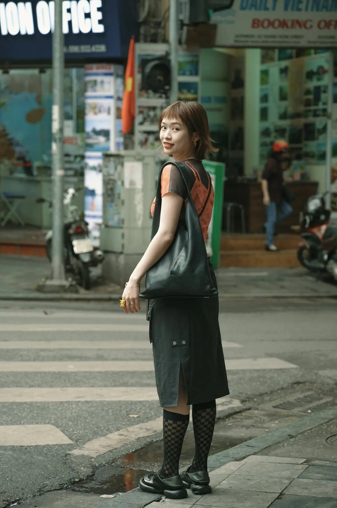 A woman standing on the side of a street