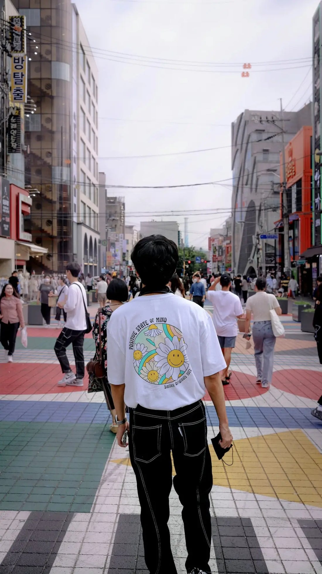 a man walking down a street next to tall buildings