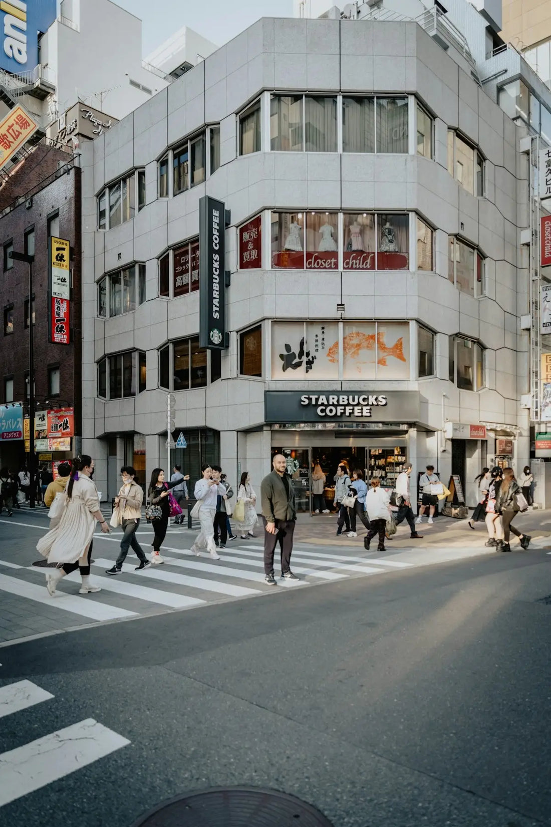 a group of people crossing a street in front of a building