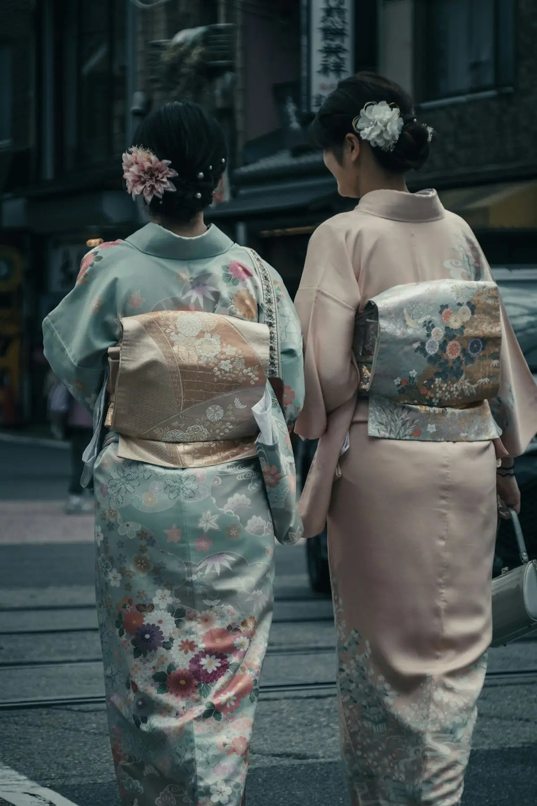 two women in kimonos walking down the street